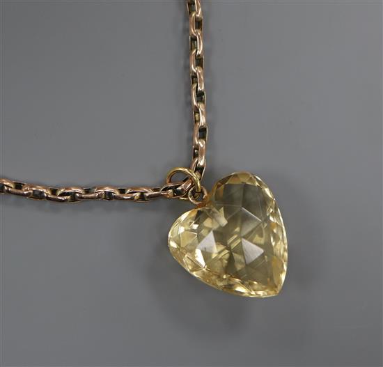 A heart shaped facetted citrine pendant, on an early 20th century 9ct chain, pendant 17mm.